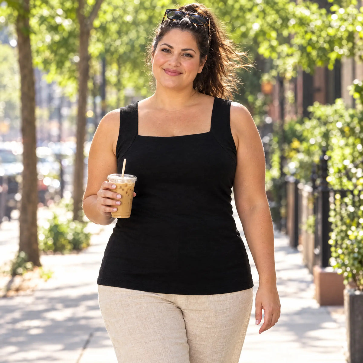 The same woman on a sunny sidewalk in the Black SmartFit tank: fresh, dry and smiling