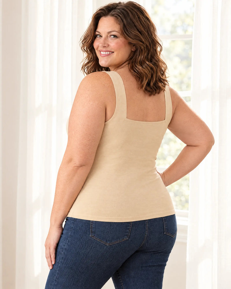 Curvy woman looking over her shoulder by a sunny window in the Beige bra tank