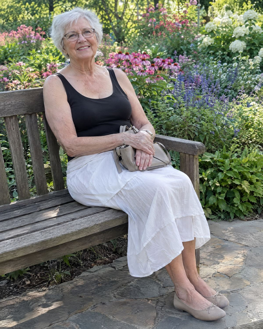 Woman in her eighties relaxing on a garden bench in a black tank and white skirt