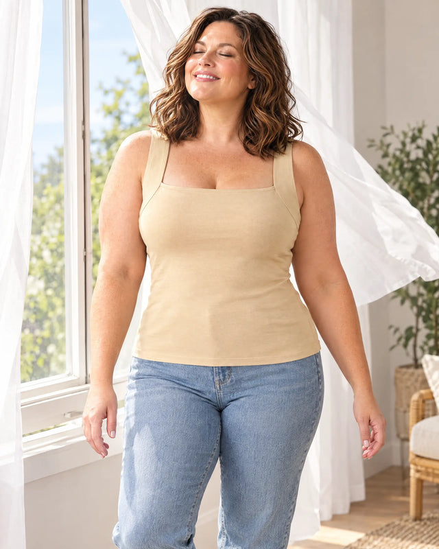 Curvy woman by an open window with the breeze in the Beige bra tank