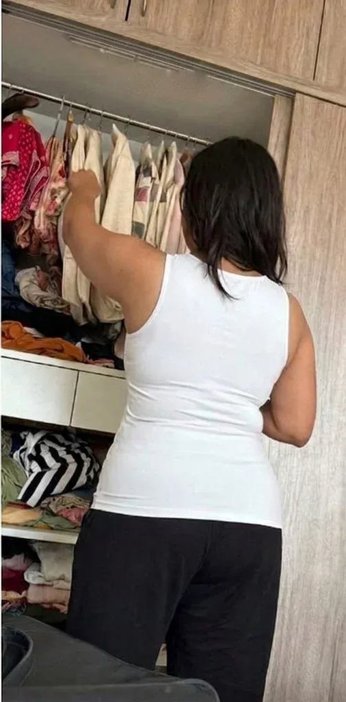 Woman at her closet in a white tank, back view: smooth from shoulders to waist