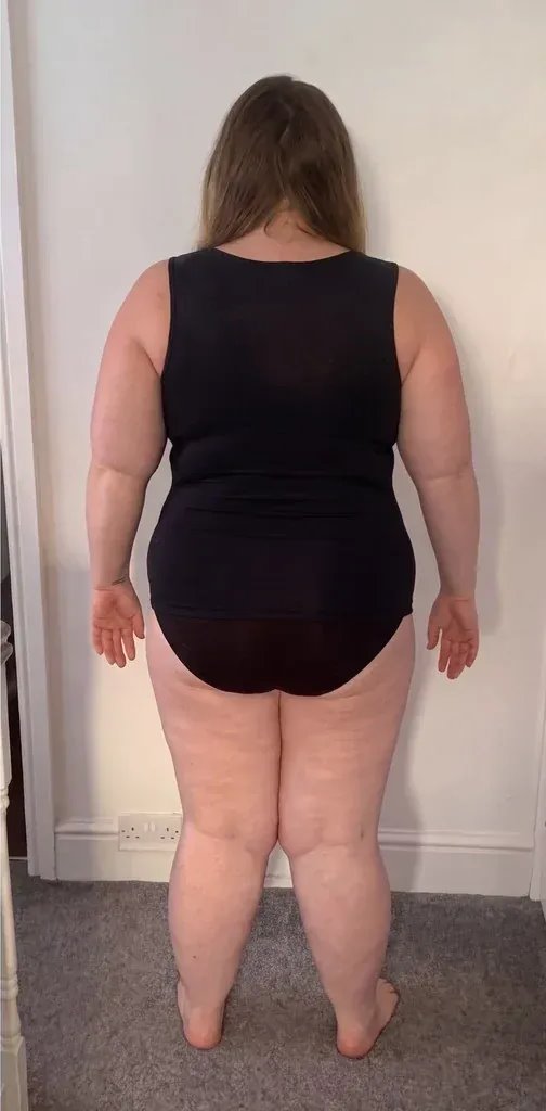 Curvy woman in a black tank, back view: the tank lies flat from shoulders to hips